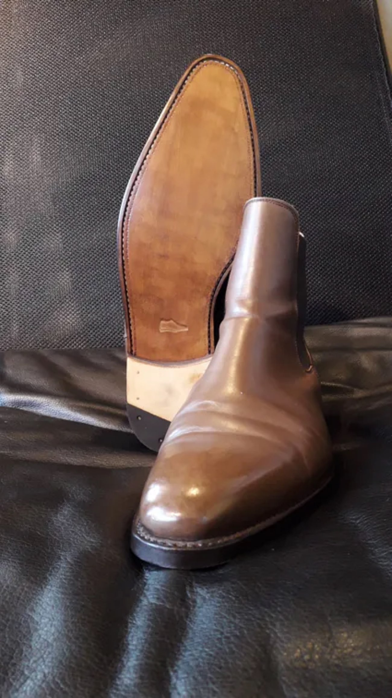 Bottine de cuir brun posée sur sa forme, dans l'atelier de la cordonnerie